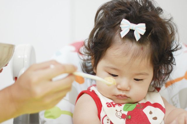 ご飯を食べさせてもらう赤ちゃん