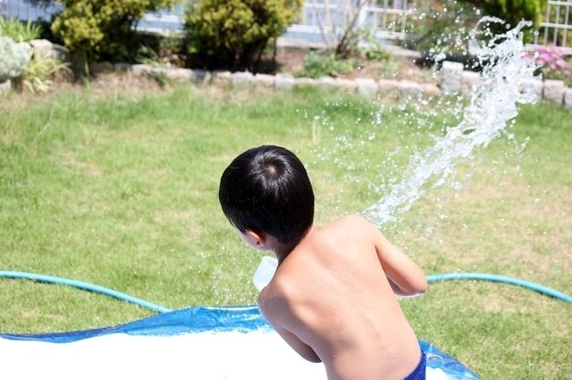 ホースで水遊びする子ども